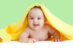 Glad baby med gult håndklæde