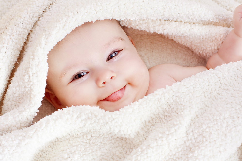 Glad baby med hvidt håndklæde
